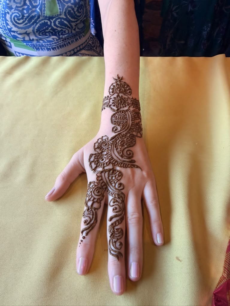 Minimal floral henna design on the back of a hand
